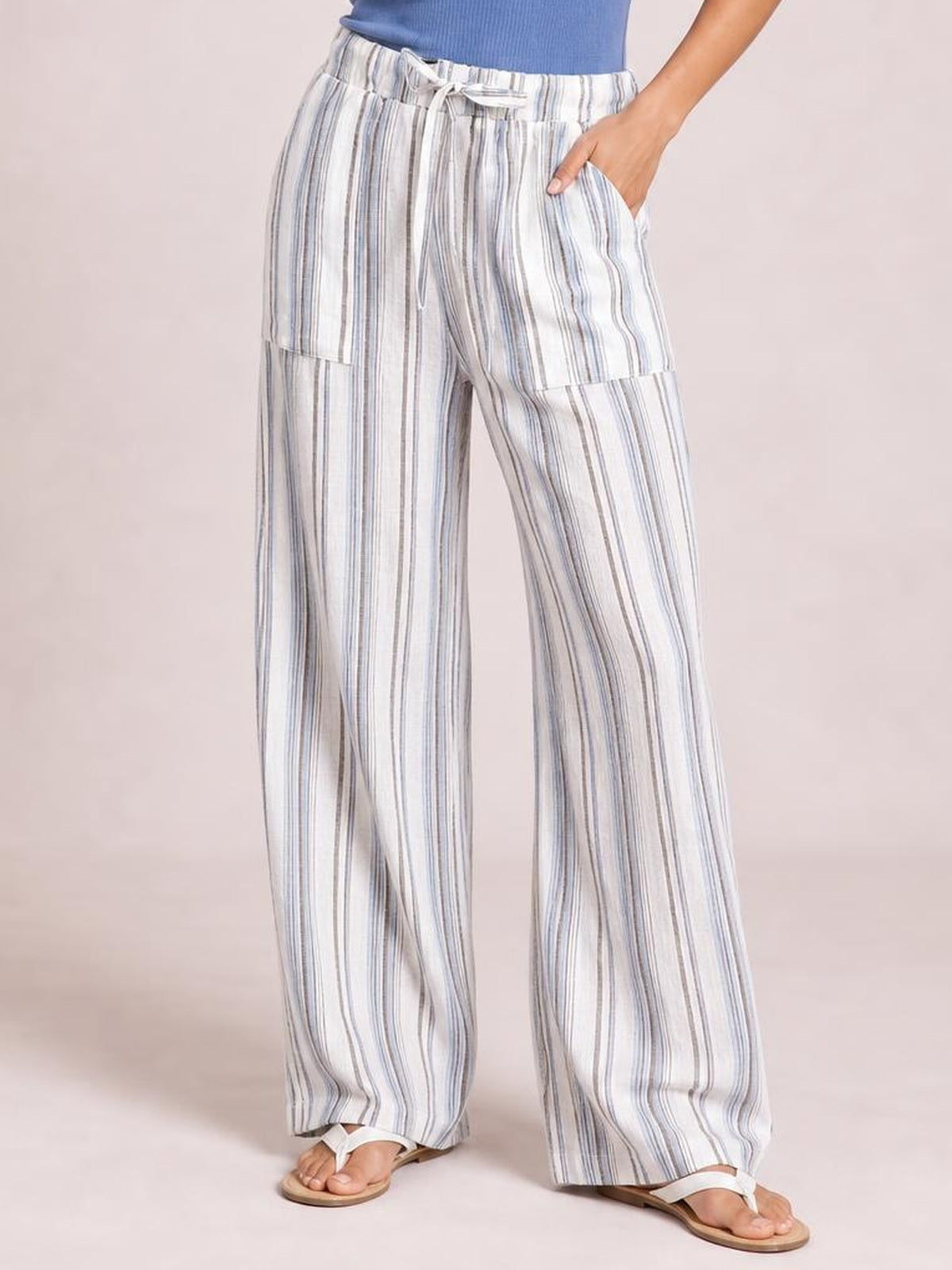 Model wearing white and blue striped wide leg pants with a drawstring waist, side pockets, and relaxed full-length silhouette.