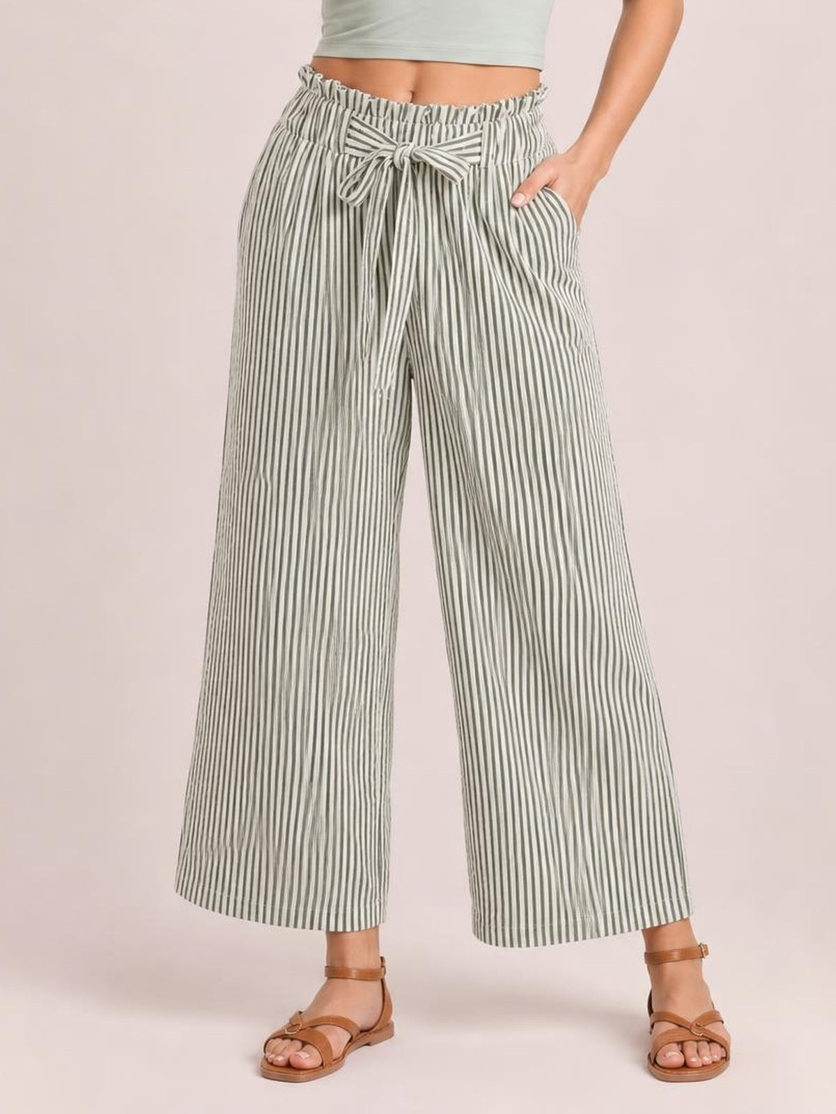 A model wears gray-and-white striped wide-leg paper bag pants with an elastic waist, front tie, side pockets, and ankle-length hems.