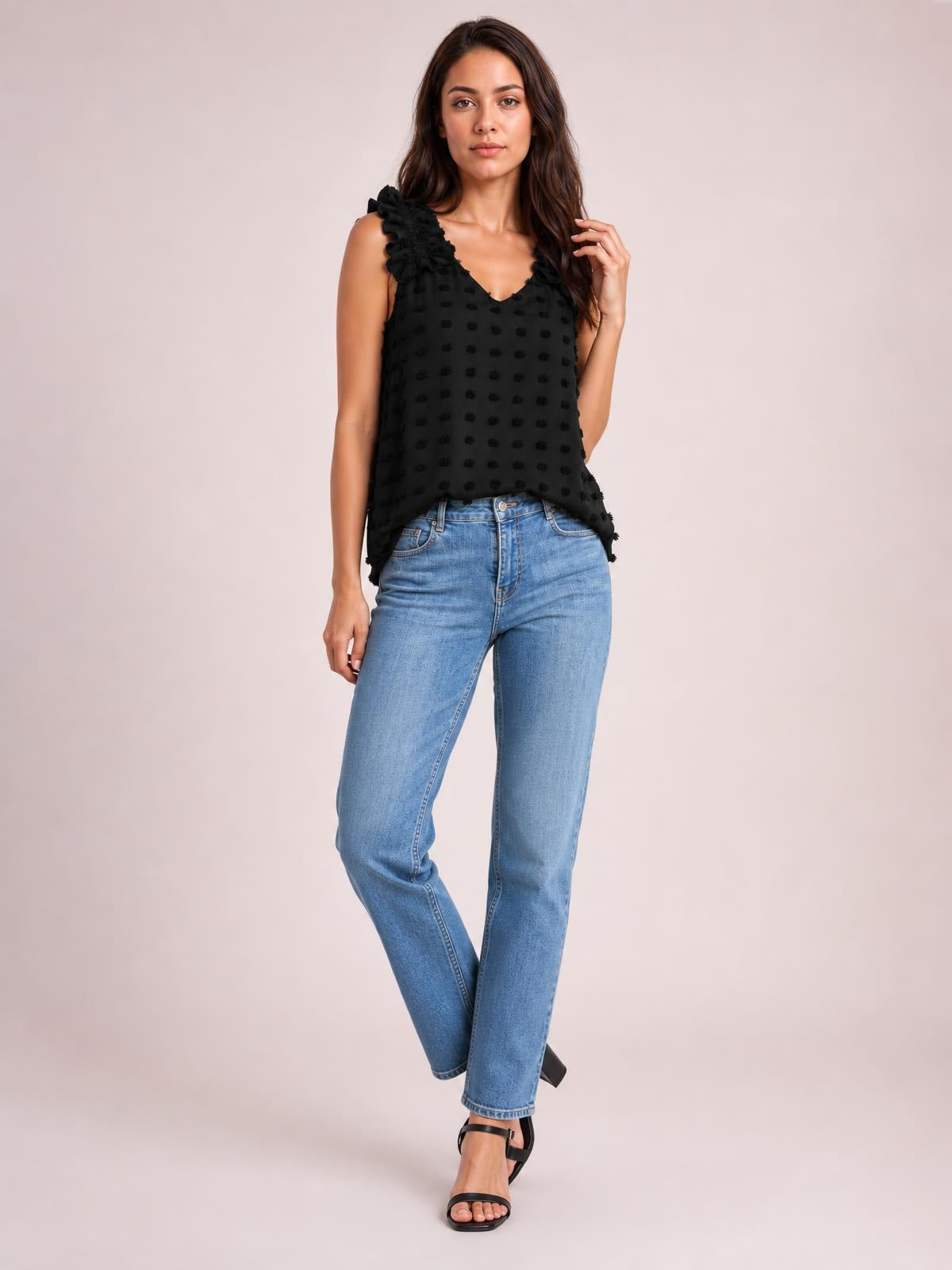 A model poses in a black Swiss dot V-neck tank with ruffled shoulder straps, a relaxed straight silhouette, and a slightly flared hem.