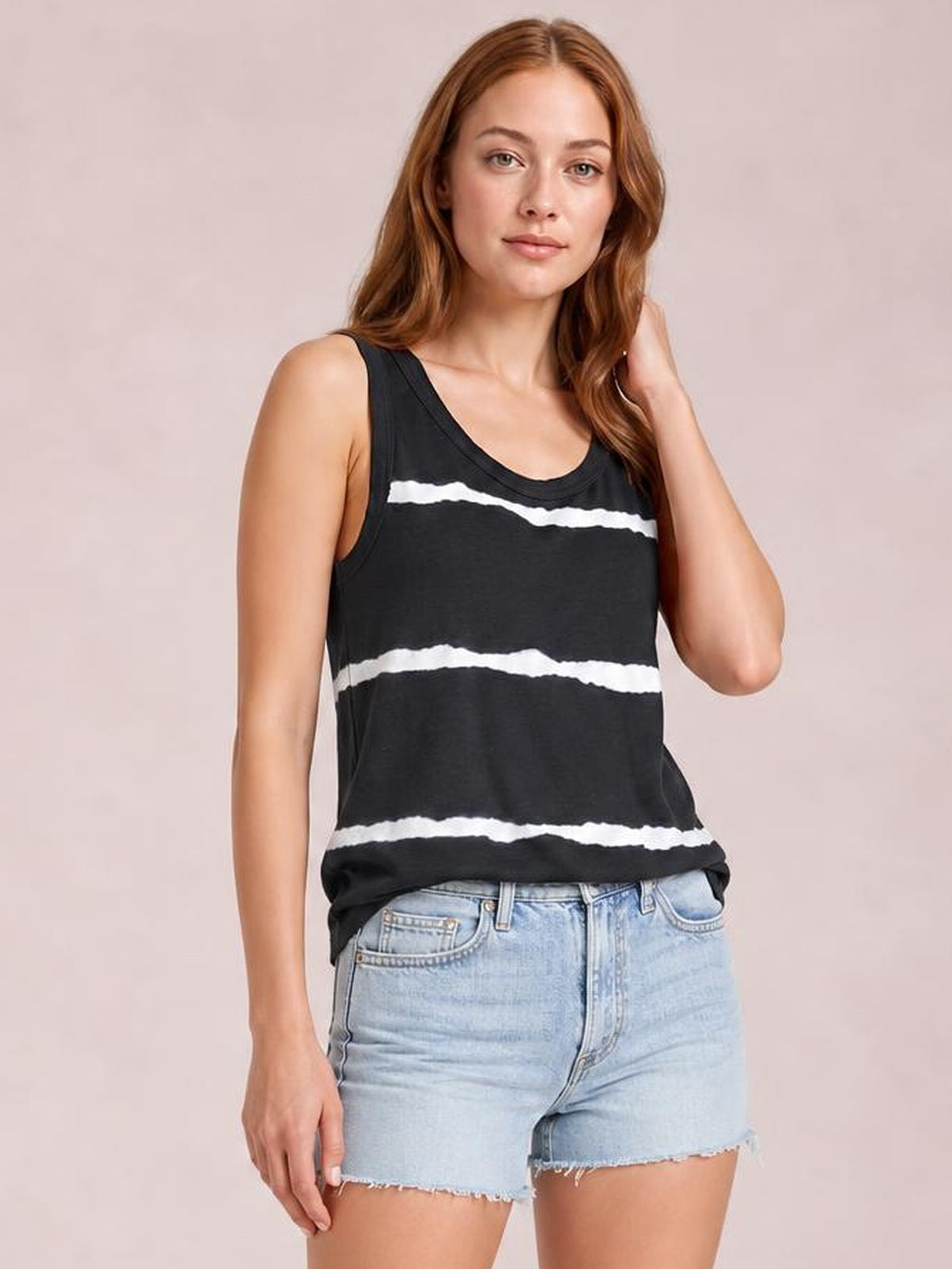 A model wears a black tie-dye round neck tank with white horizontal bands, wide shoulder straps, a relaxed silhouette, and a slightly curved hem.