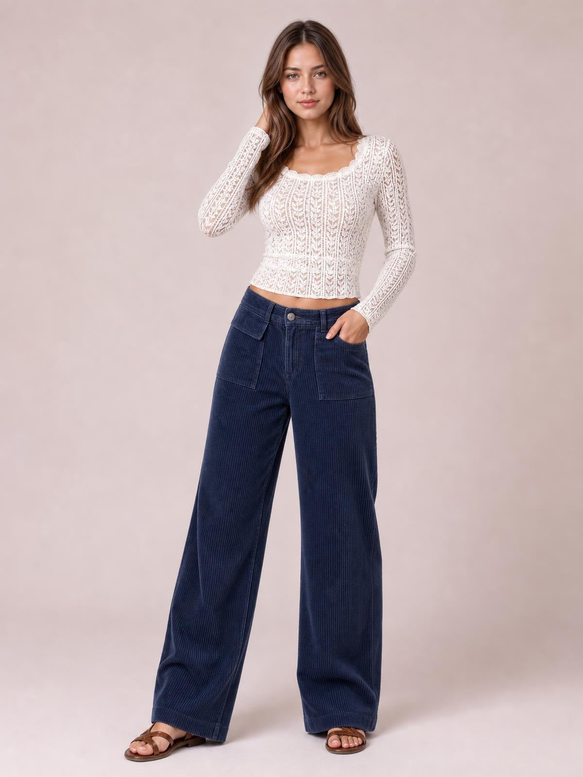 A model poses in navy wide-leg corduroy pants with a high-rise waist, front patch pockets, belt loops, and a button fly.