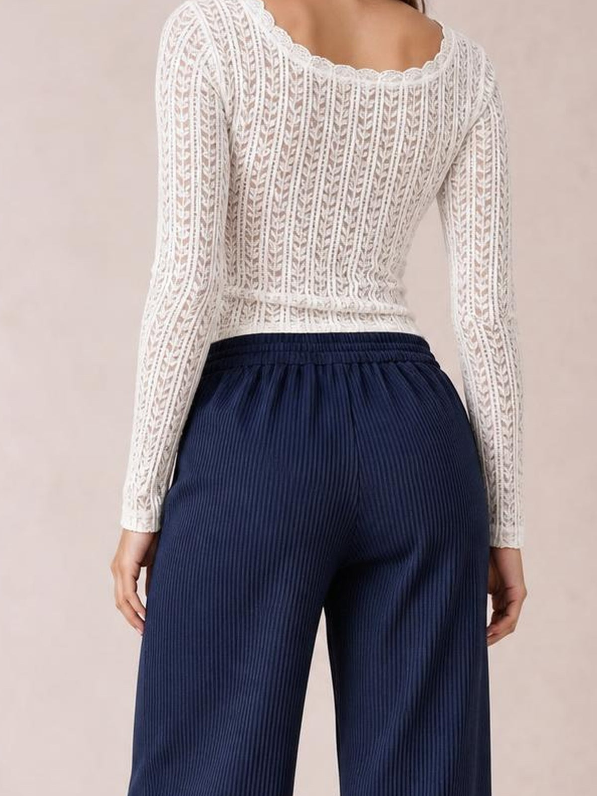 Model shown from behind wearing navy wide-leg corduroy pants with a gathered elastic waistband, vertical ribbed texture, and relaxed flowing silhouette.