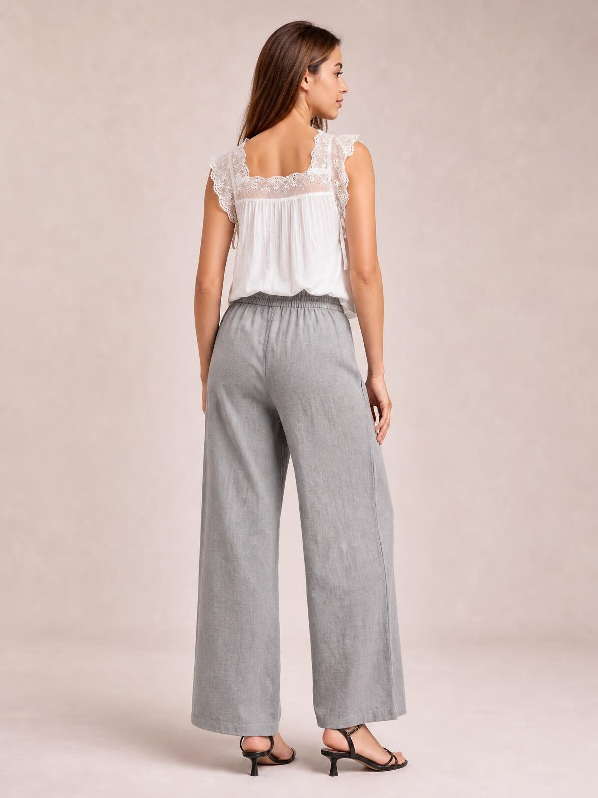Model shown from behind wearing light gray wide leg pants with an elastic waistband and relaxed full-length silhouette.