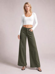 Model poses in olive-green wide leg pants with front patch pockets, belt loops, button closure, and a full-length relaxed silhouette.