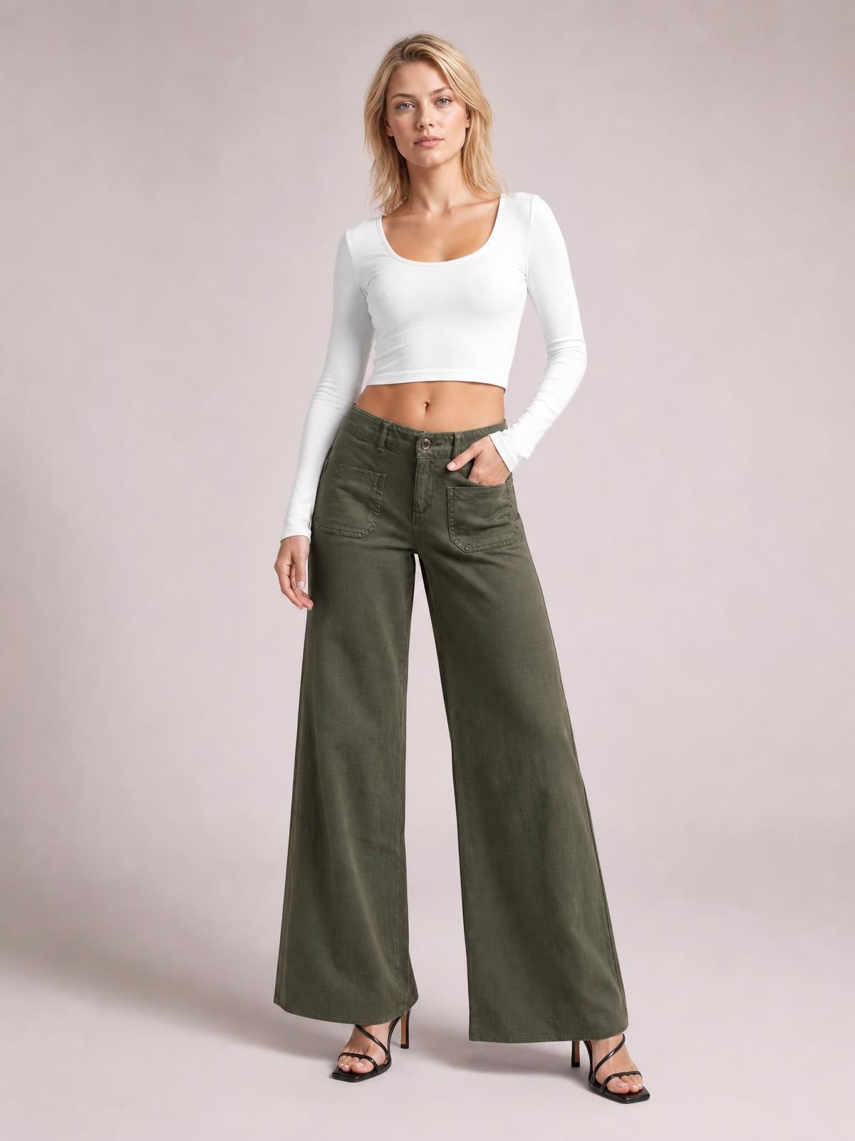 Model poses in olive-green wide leg pants with front patch pockets, belt loops, button closure, and a full-length relaxed silhouette.
