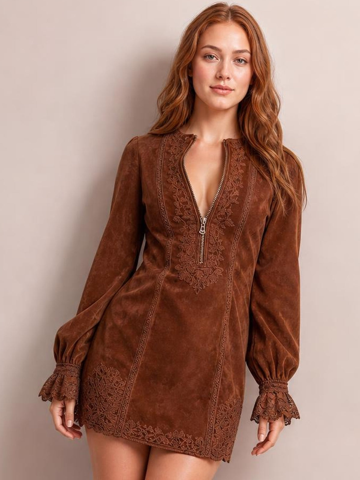Model stands in a brown long-sleeve mini dress with a front zipper, floral lace detailing, fitted straight silhouette, and flared lace-trimmed cuffs.