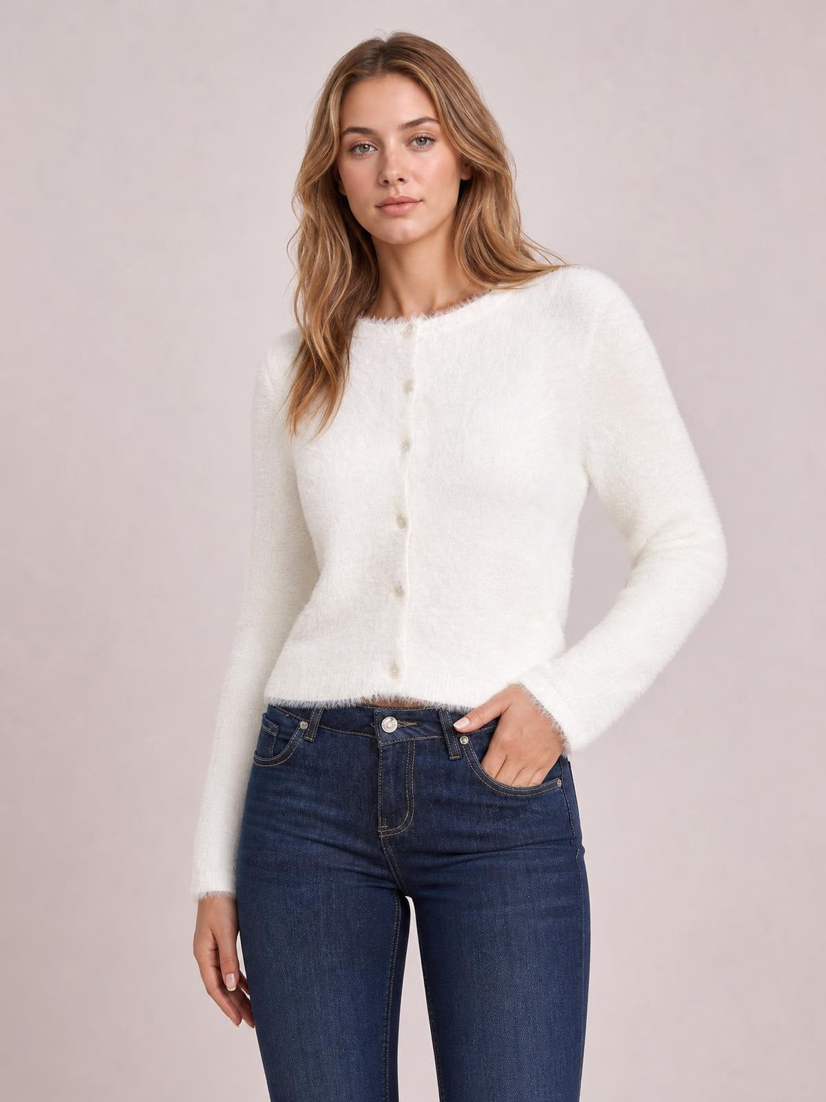 Model wearing a white fuzzy knit button-down cardigan with a soft texture, crew neckline, long sleeves, fitted silhouette, and front buttons.