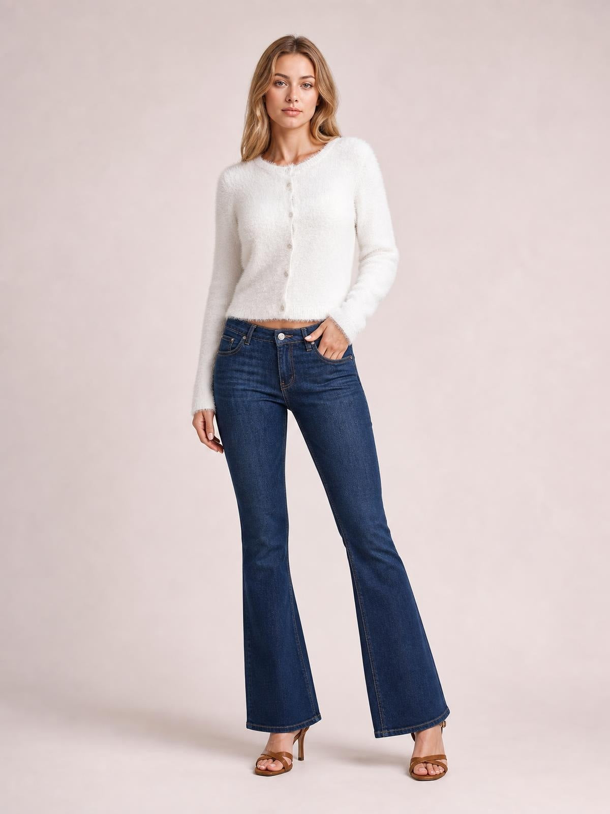 Model wears a white fuzzy knit button-down cardigan with a round neckline, long sleeves, soft texture, and cropped fitted silhouette.