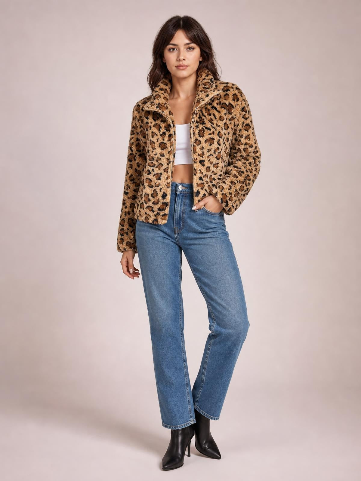 Model poses in a fuzzy tan and black leopard-print turtleneck jacket with a front zip closure, relaxed silhouette, and one hand in her jeans pocket.