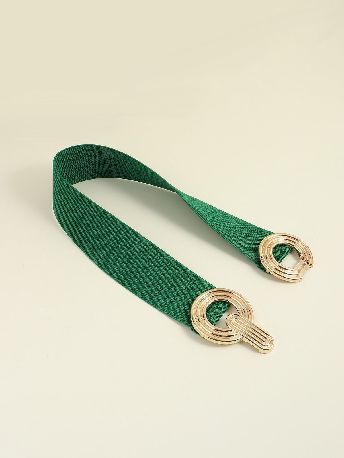 A green elastic wide belt features a sleek 2-inch band and polished gold geometric buckle with interlocking rounded forms.