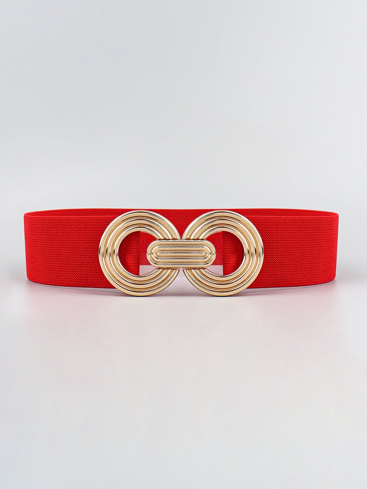 Red elastic wide belt displayed flat with a polished gold alloy geometric buckle featuring interlocking rounded forms and a layered dimensional design.