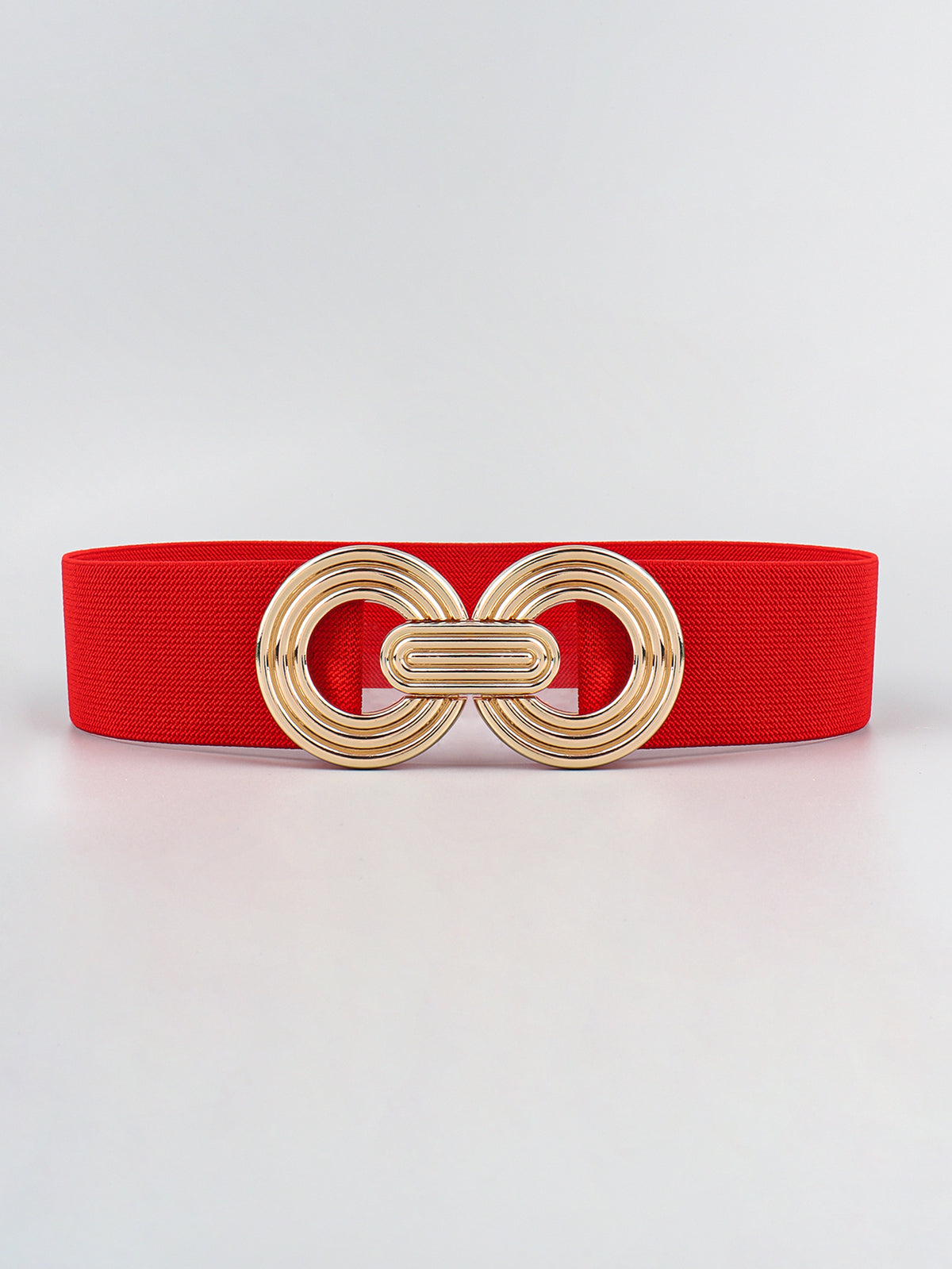 Red elastic wide belt displayed flat with a polished gold alloy geometric buckle featuring interlocking rounded forms and a layered dimensional design.