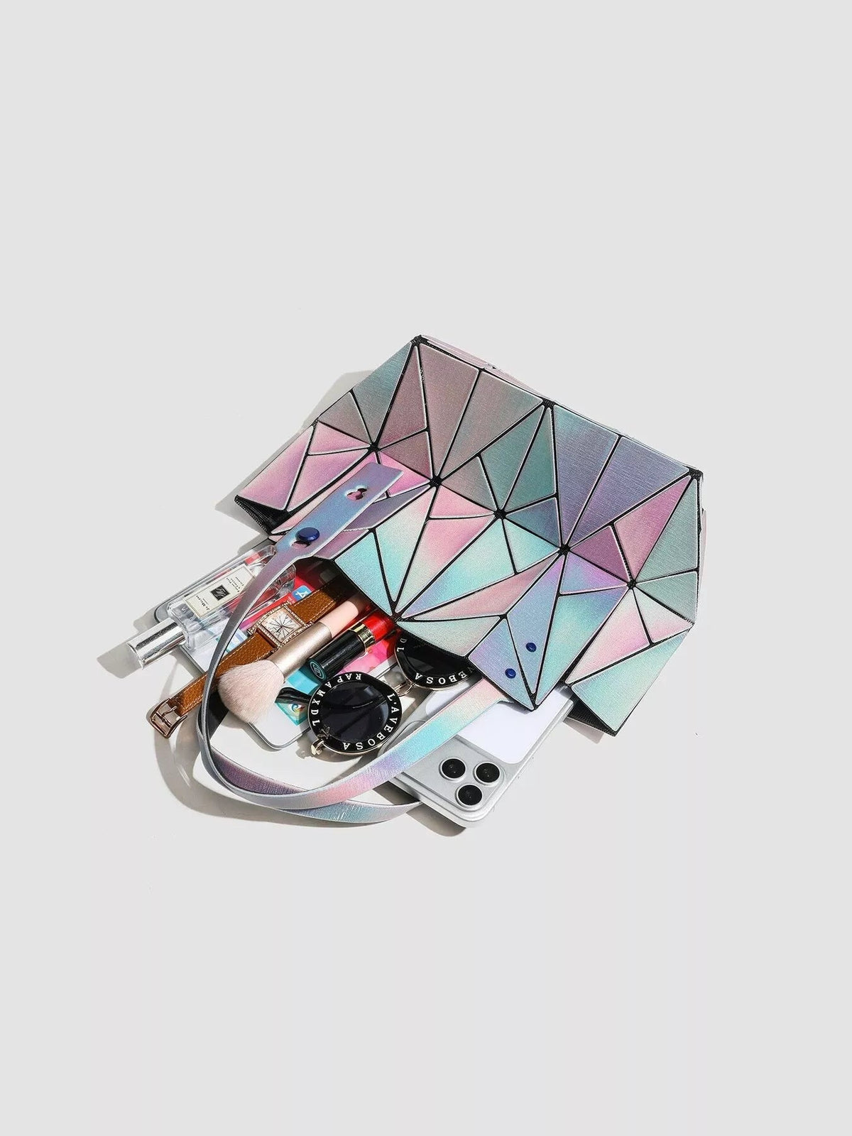 Medium geometric iridescent PVC shoulder bag with angular multicolor panels, a structured silhouette, and a long matching strap, shown open.