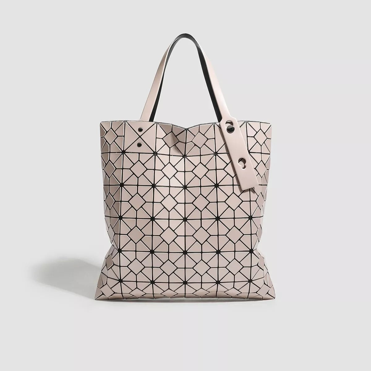 Medium blush-pink PVC handbag with a geometric black lattice pattern, structured tote silhouette, open top, and two long handles.