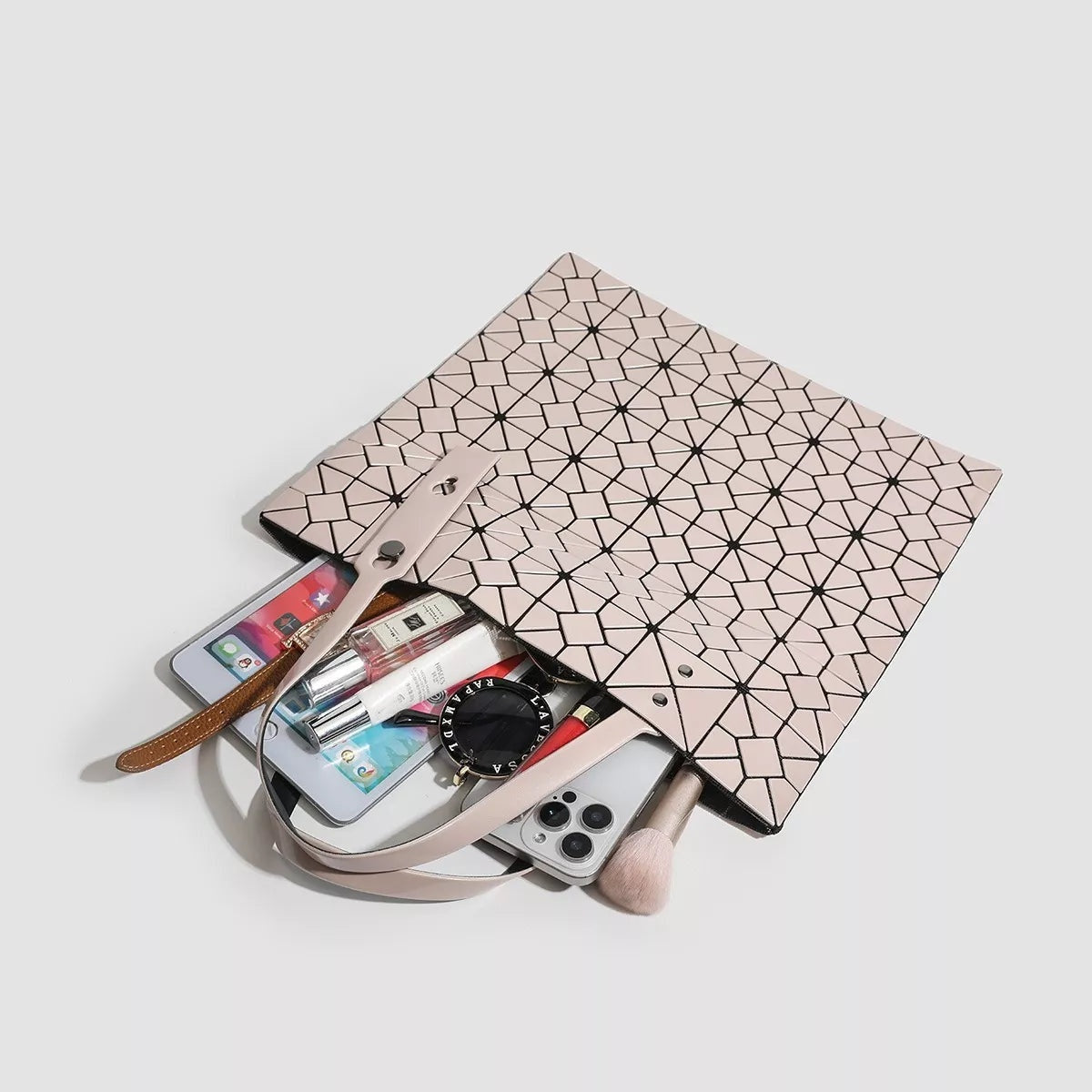 Medium blush pink PVC handbag with a geometric lattice pattern, open top, dual handles, and a structured rectangular silhouette.