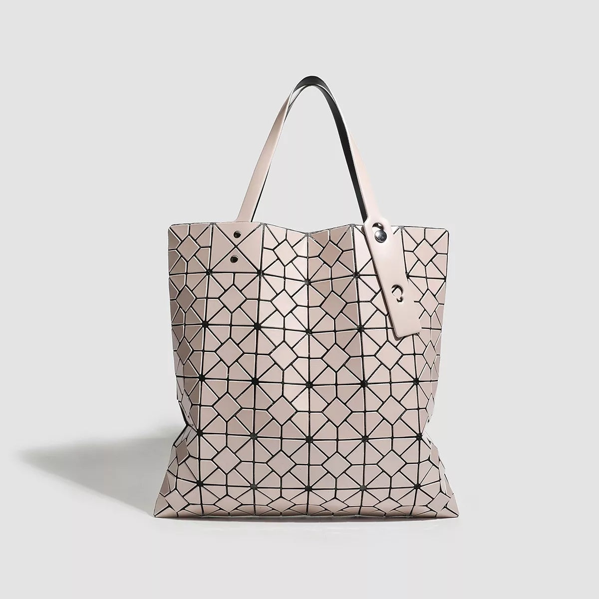 Medium PVC handbag with a pale blush geometric lattice pattern, structured tote silhouette, and twin top handles with secure metal fastenings.