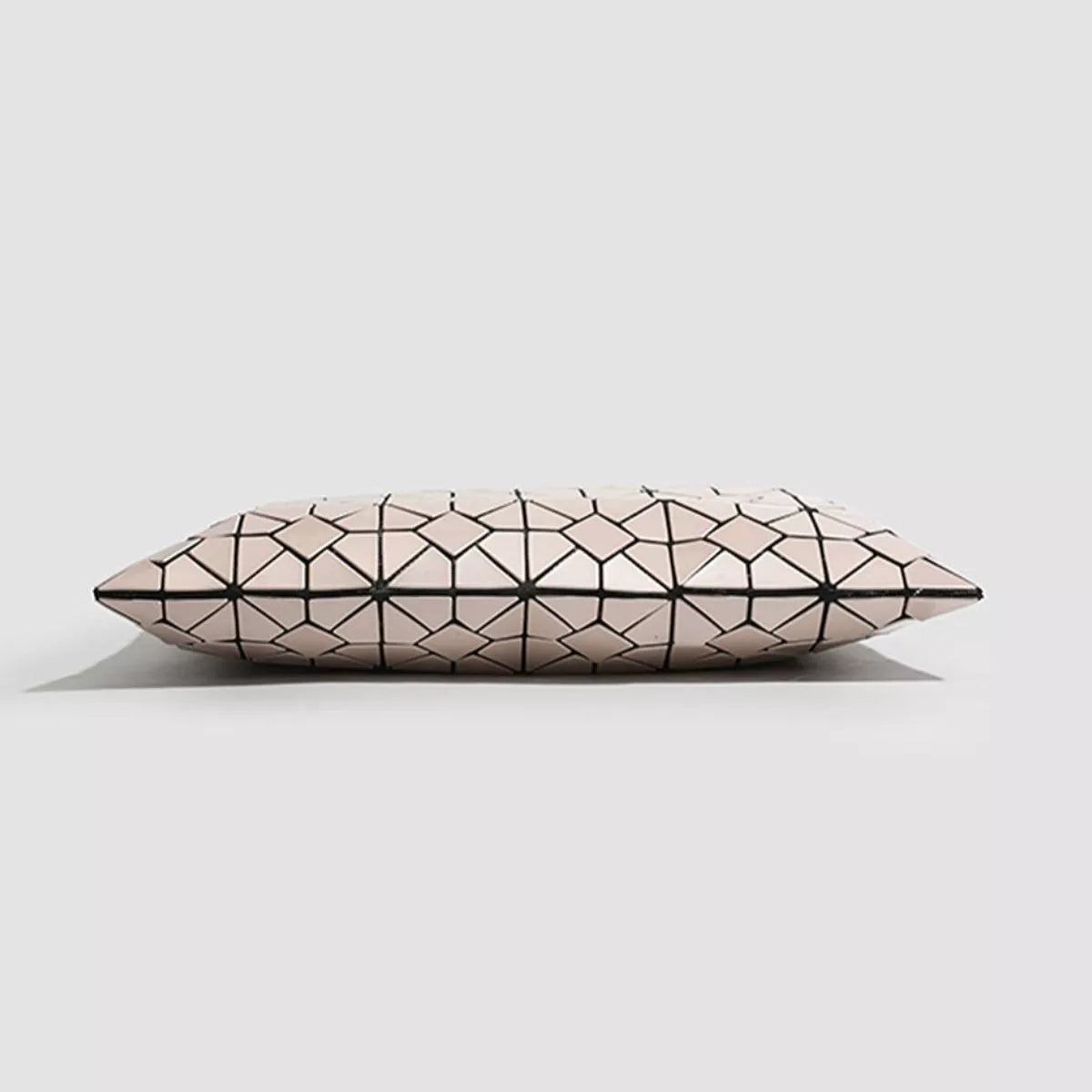 A medium PVC handbag in pale beige features a bold black geometric lattice pattern and an elongated, softly structured silhouette with tapered ends.
