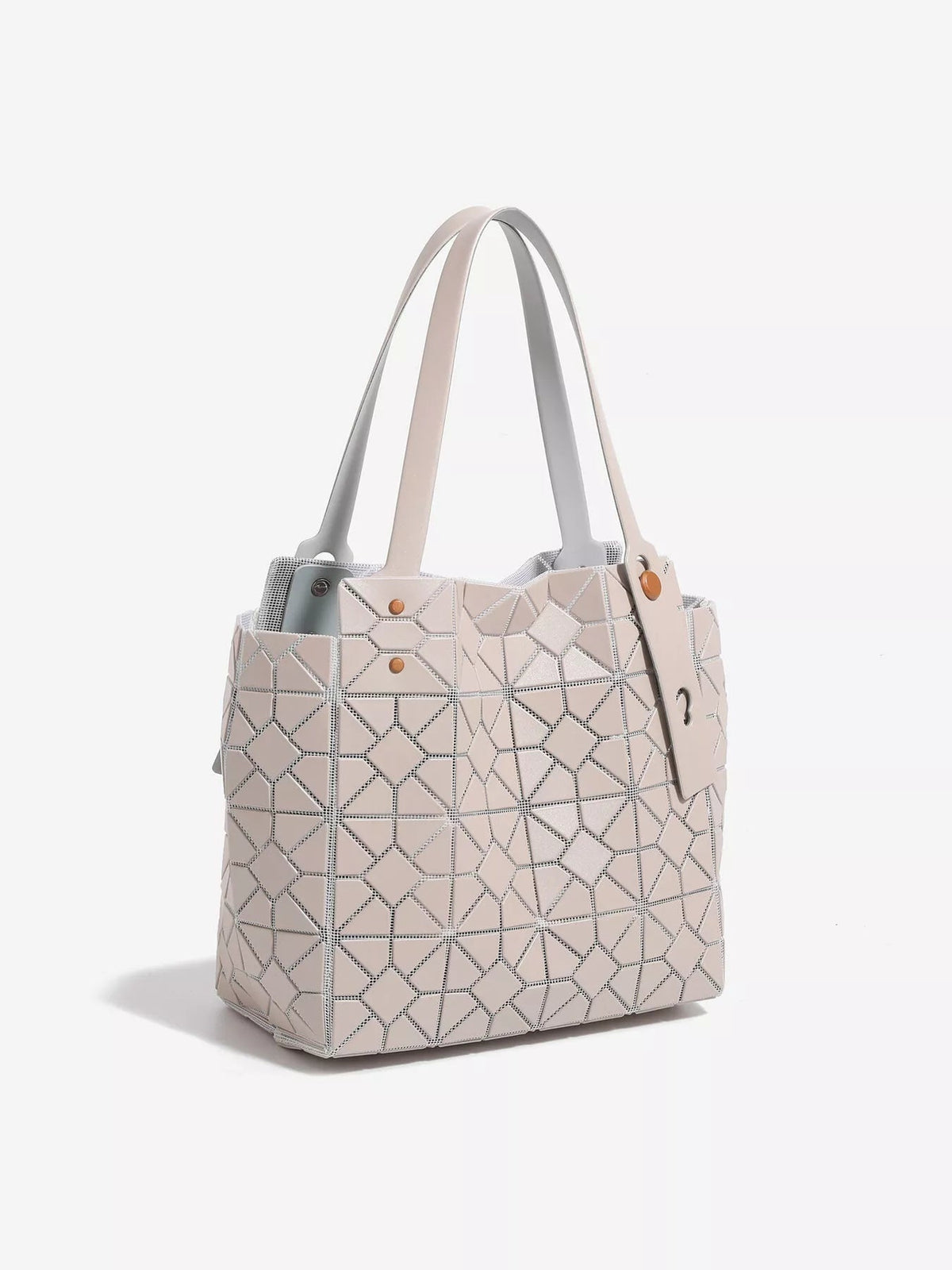 A medium pale pink PVC handbag with a structured silhouette, geometric lattice paneling, double top handles, and studded envelope-style details.