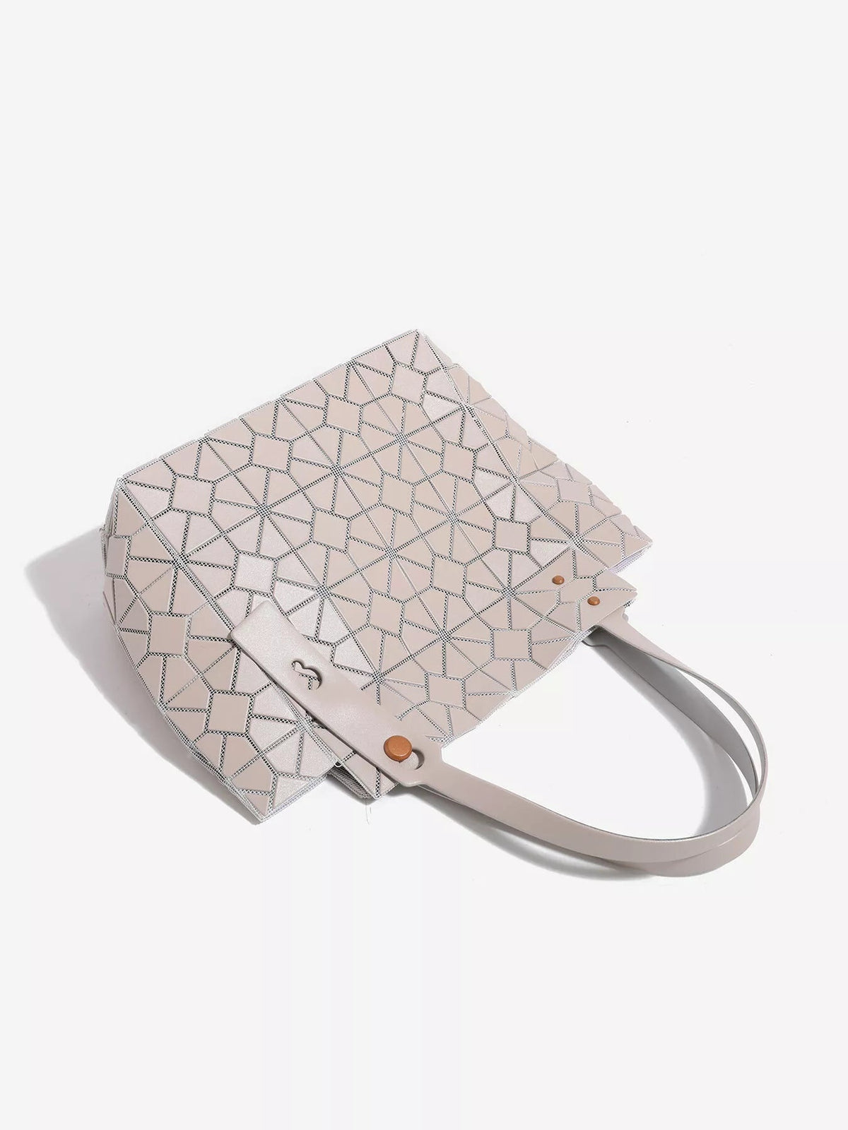 Medium structured PVC handbag in pale blush with a geometric lattice pattern, rectangular silhouette, long double handles, and button-fastened strap details.
