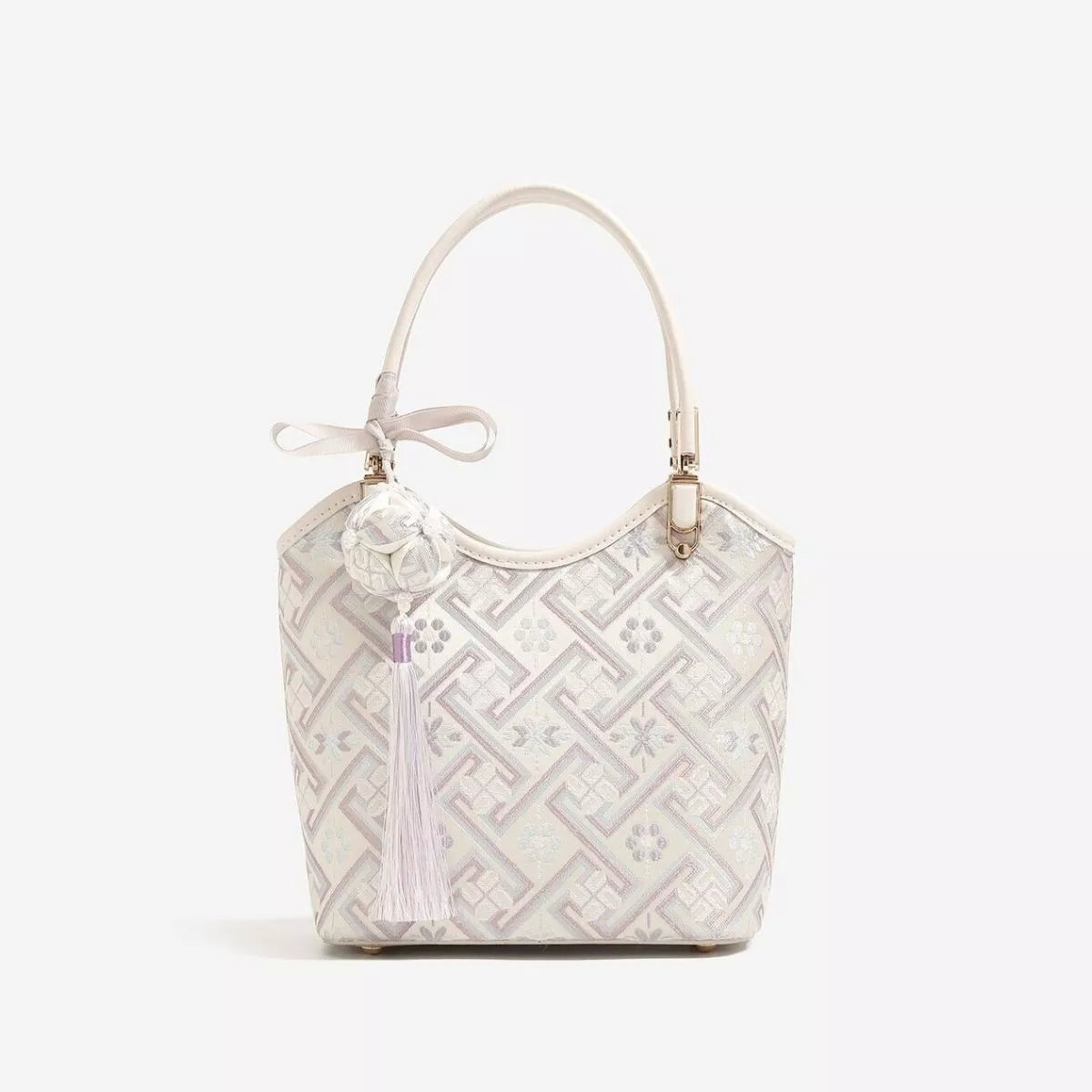 Small cream polyester handbag with a geometric pattern, structured bucket silhouette, curved top handle, and gold-tone hardware.