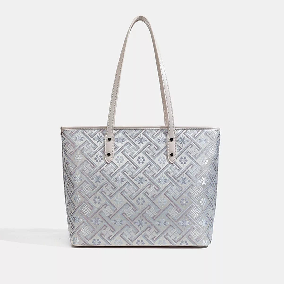 Medium faux leather tote bag in light gray with a geometric patterned body, structured rectangular silhouette, and double stitched shoulder handles.