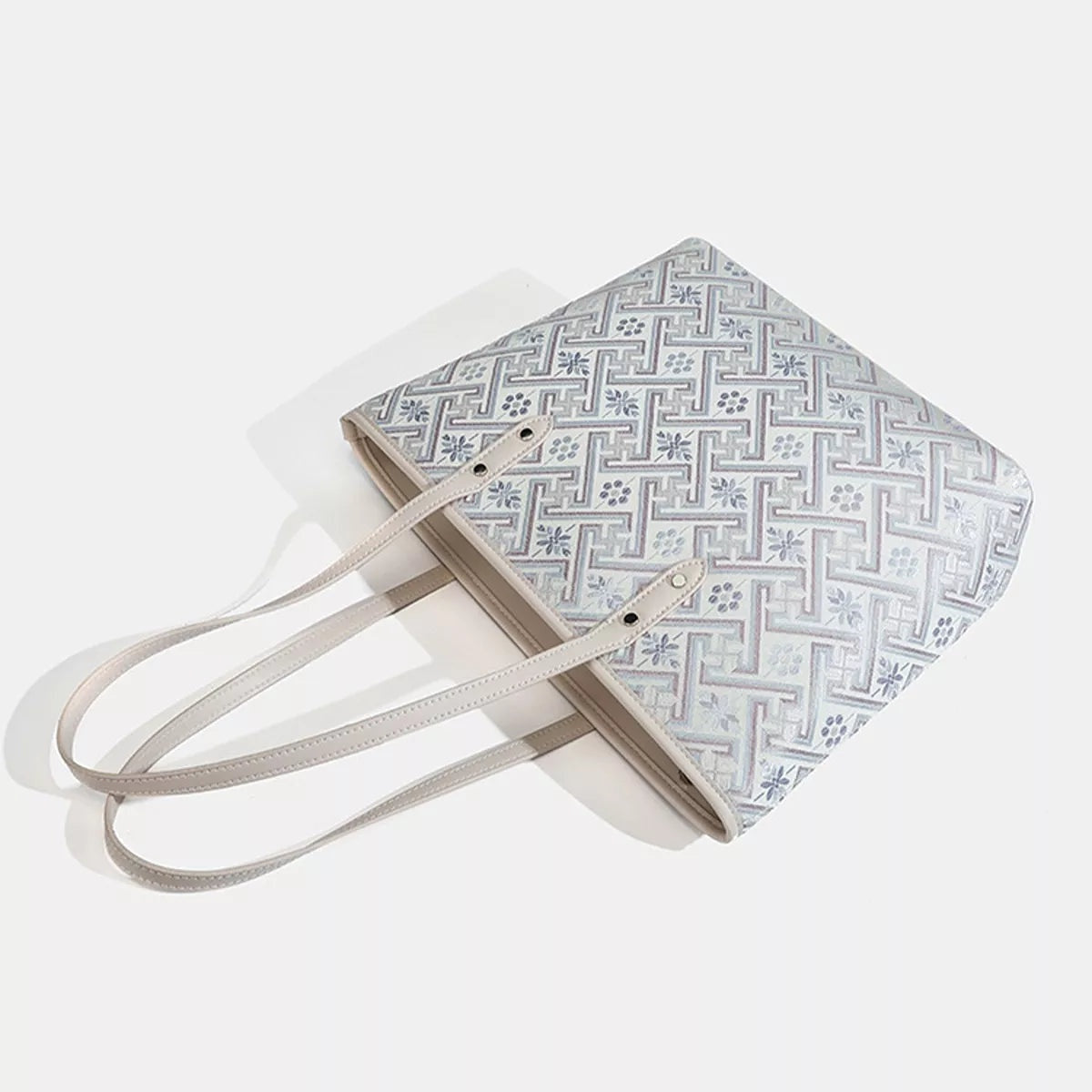 Medium faux leather tote bag with a light geometric pattern, structured rectangular silhouette, and two slim shoulder straps.