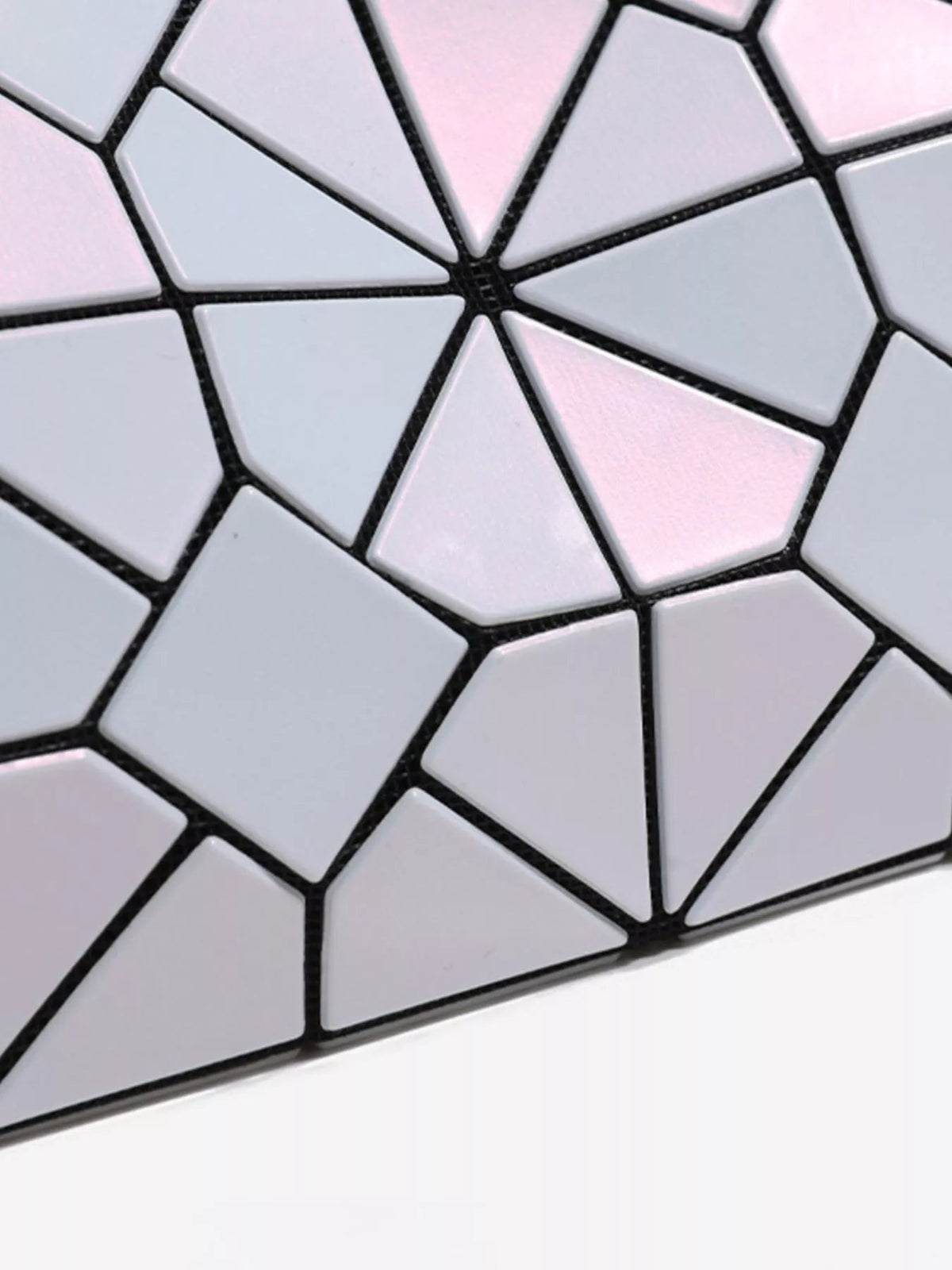 Close-up of a small PVC shoulder bag with an iridescent pale pink and white geometric prism mosaic framed by black seams.