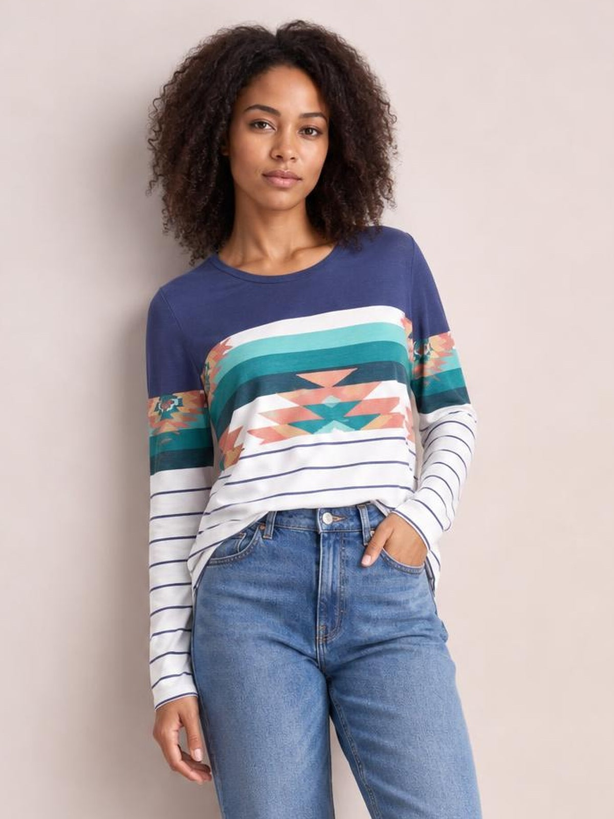 A model poses in a navy geometric round neck long sleeve T-shirt with colorful patterned bands, horizontal stripes, and a relaxed silhouette.