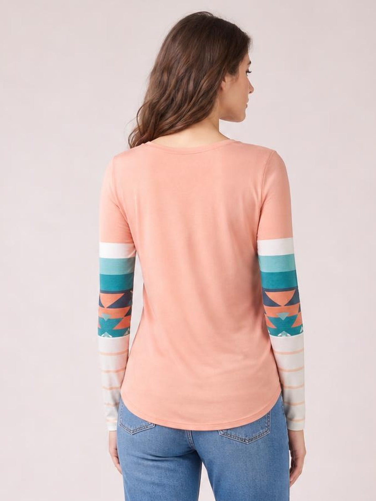 Back view of a model wearing a coral Geometric Round Neck Long Sleeve T-Shirt with colorful geometric striped sleeves and a relaxed curved-hem silhouette.