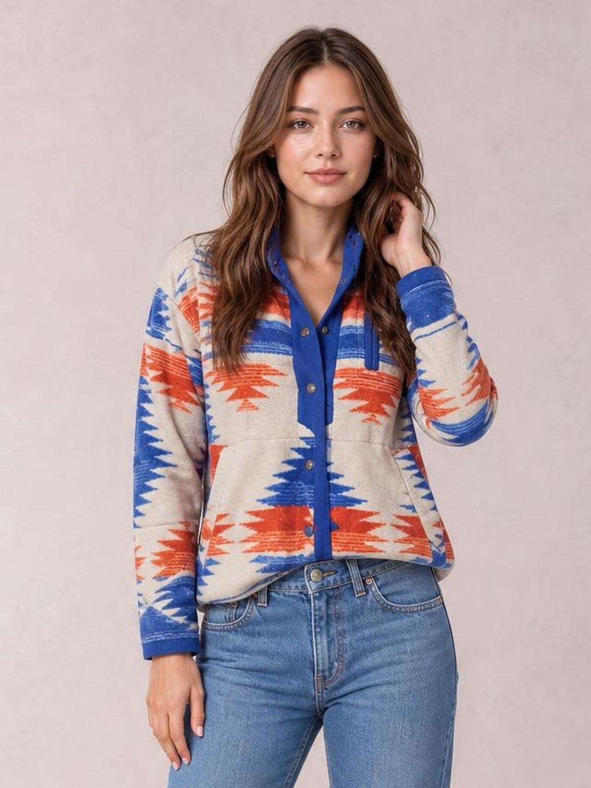 Model poses in a cream Geometric Snap Down Jacket with blue and orange geometric patterns, long sleeves, blue trim, and a relaxed silhouette.