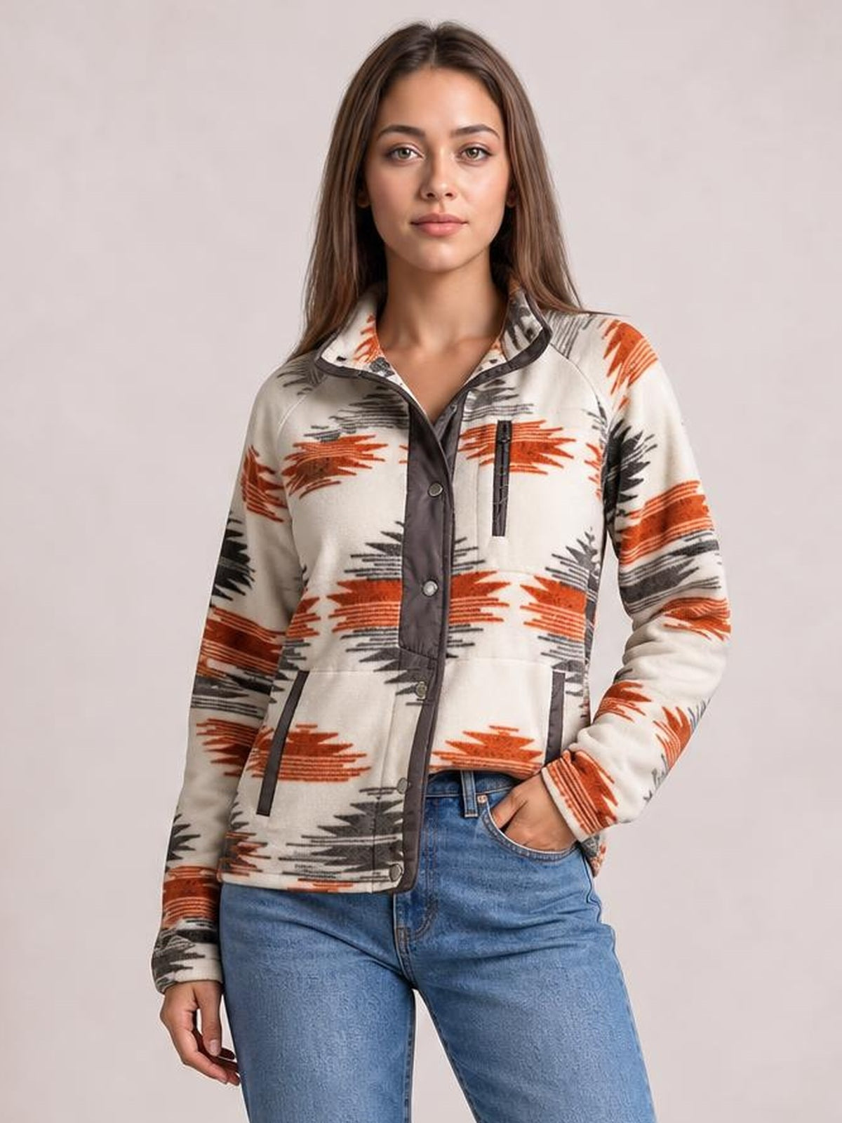 A model wears a cream geometric snap-down jacket with rust and black patterns, long sleeves, a dark button placket, and front pockets.