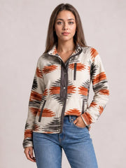 A model wears a cream geometric snap-down jacket with rust and black patterns, long sleeves, a dark button placket, and front pockets.
