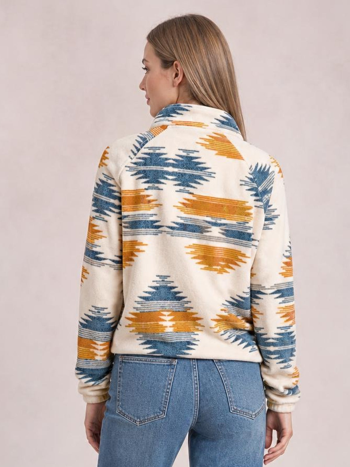 Back view of a model wearing a cream Geometric Snap Down Jacket with blue and ochre geometric print, long sleeves, a structured collar, and a relaxed silhouette.