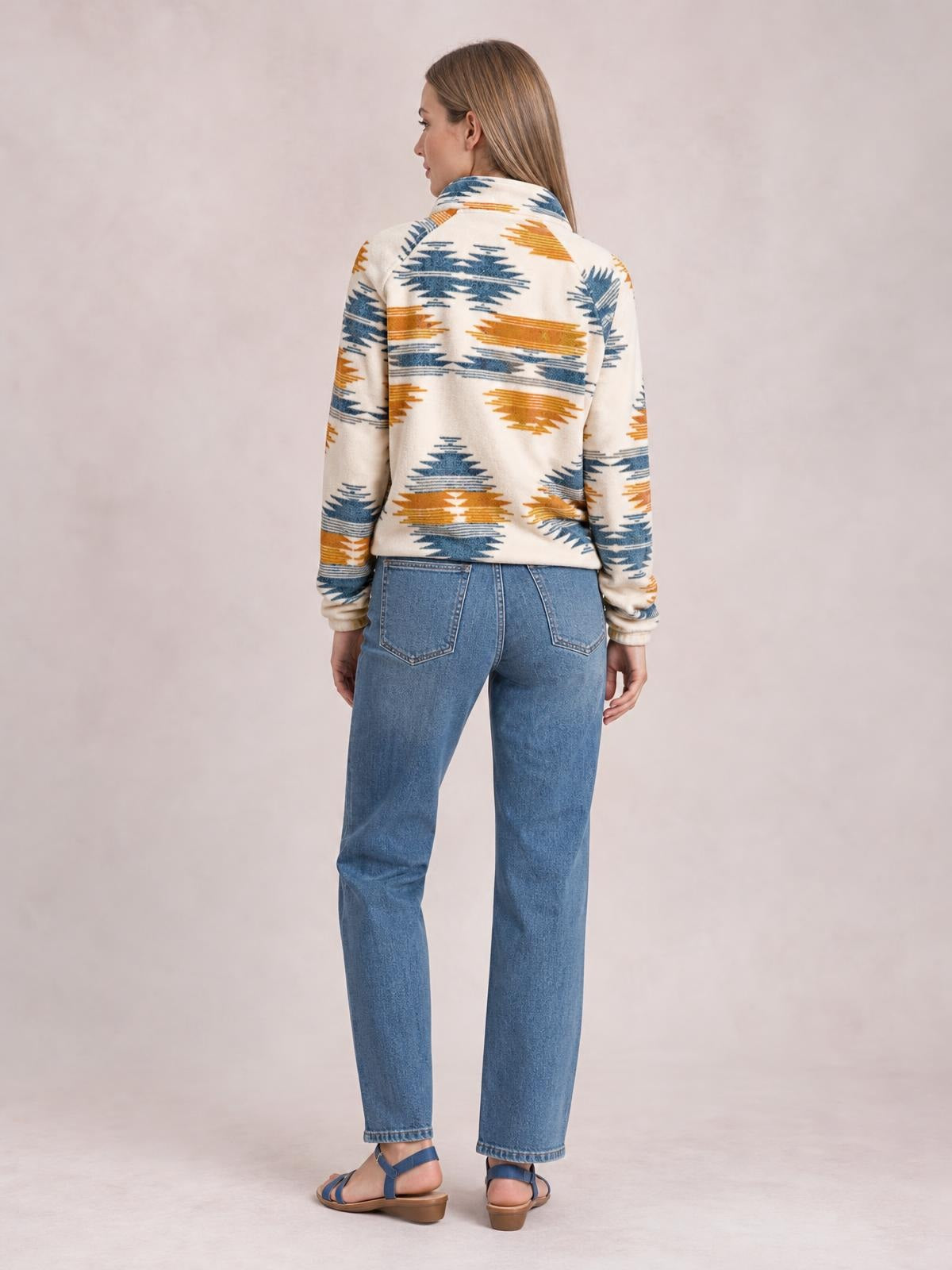 Model shown from behind wears a cream Geometric Snap Down Jacket with blue and mustard geometric print, stand collar, long sleeves, and a relaxed silhouette.