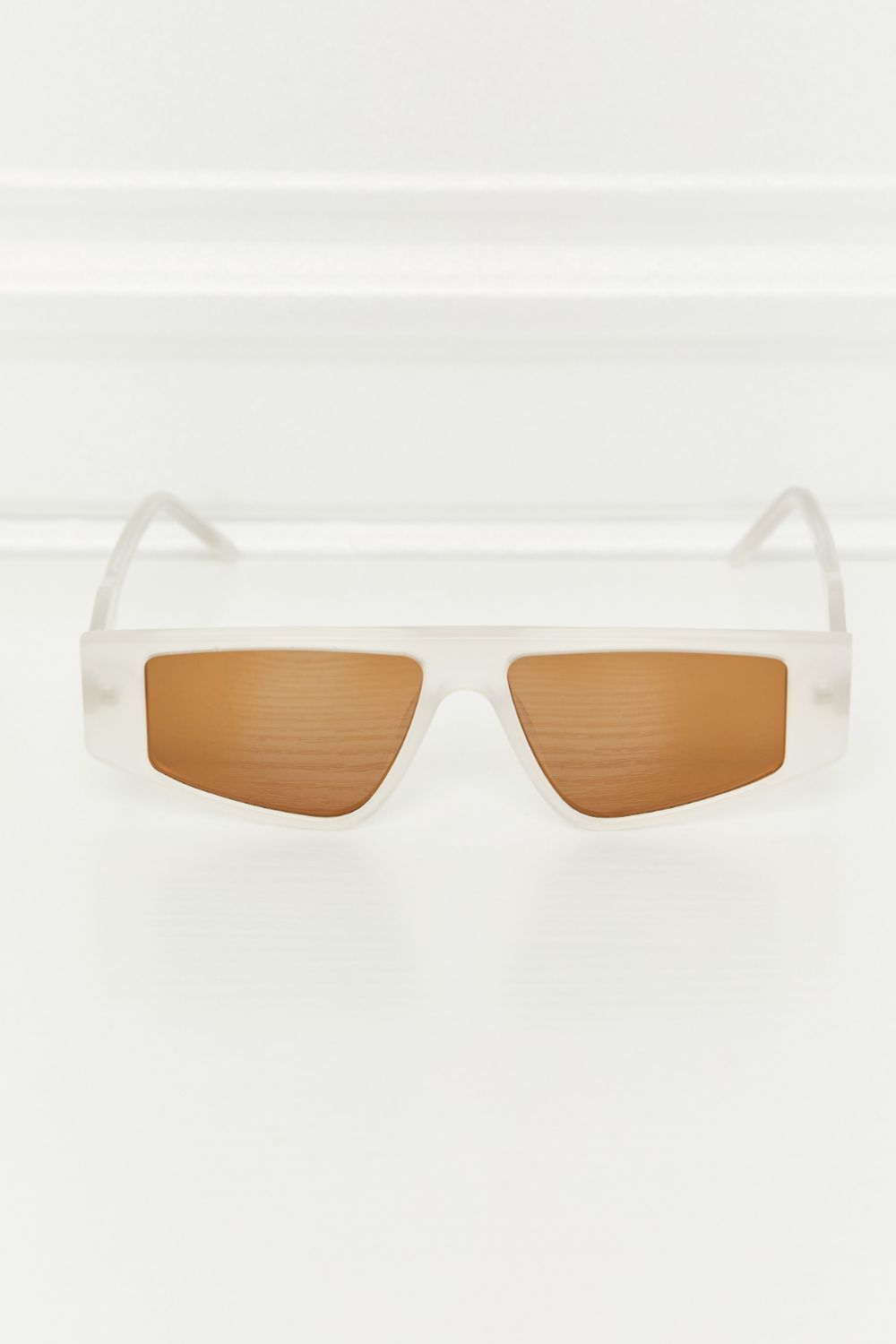 Geometric TAC polarized sunglasses with translucent acetate frames, matching temples, and warm caramel lenses in a clean, structured rectangular silhouette.