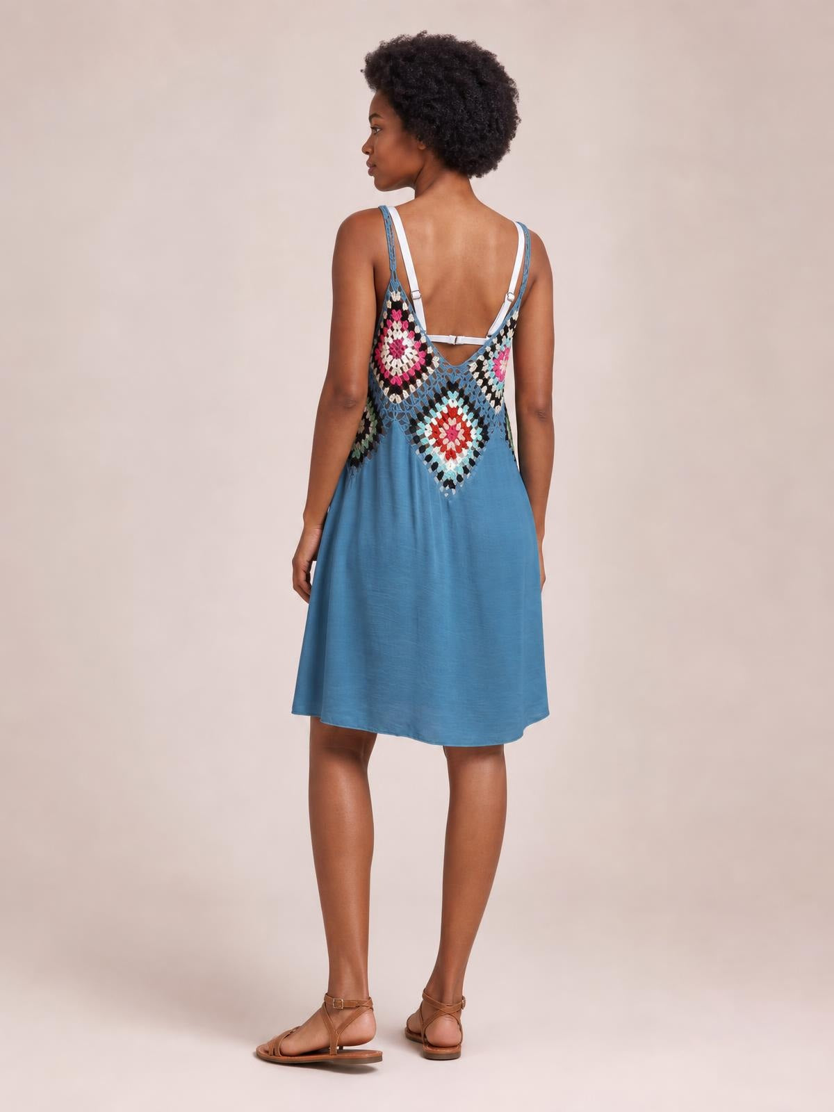 Model shown from behind wearing a blue semi-sheer geometric cover-up dress with spaghetti straps, a relaxed A-line silhouette, and decorative open back.