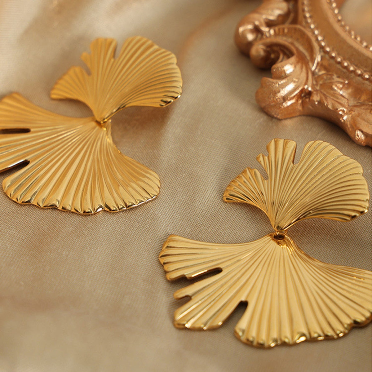 Gold-tone Ginkgo Biloba Design Stud Earrings feature sculpted fan-shaped leaves with radiating ribbed detailing and a polished 18K-plated finish.