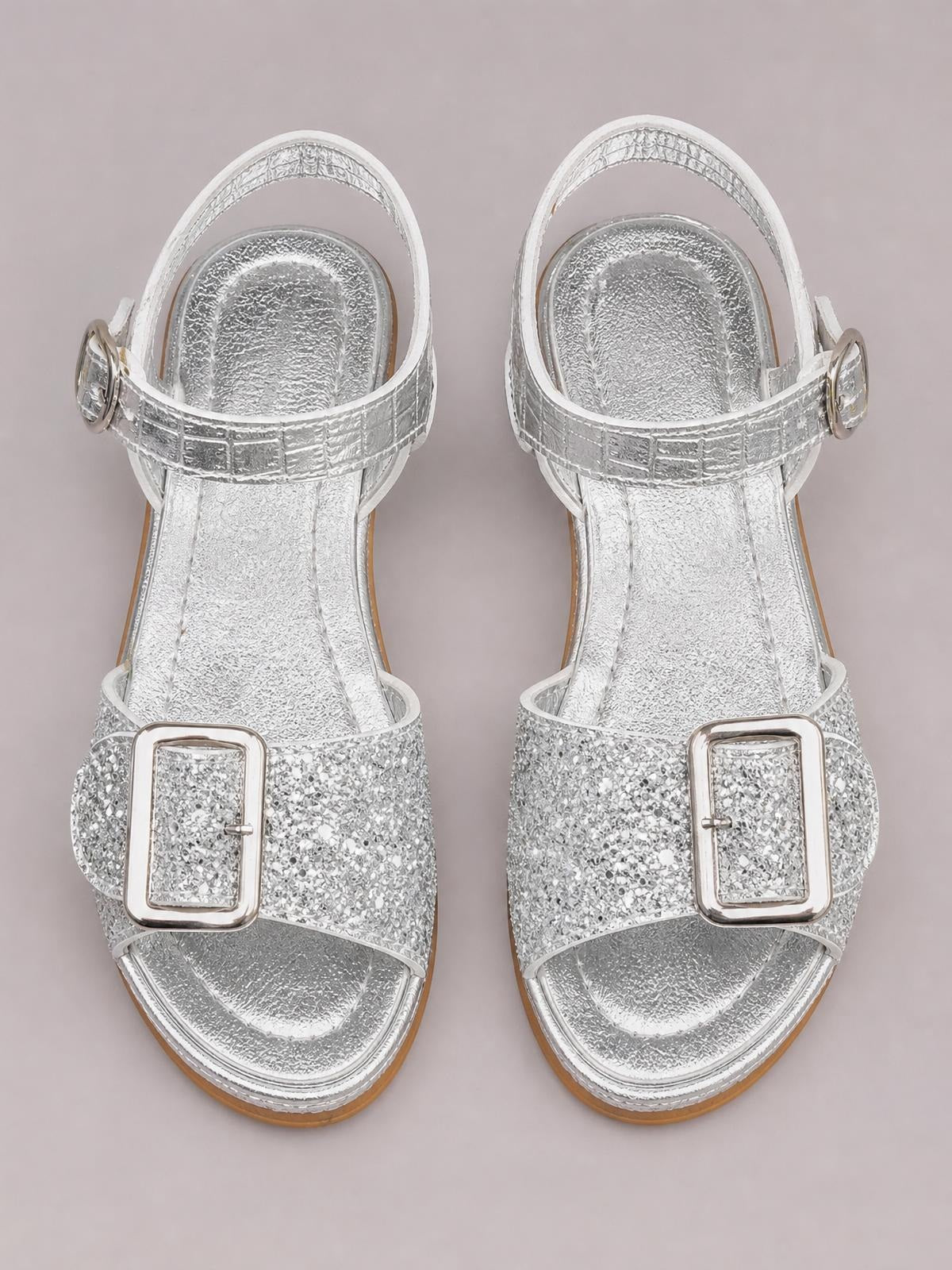 Silver glitter block heel buckle sandals feature open toes, wide front straps, ankle straps, and polished rectangular buckles on a mid-height block heel.