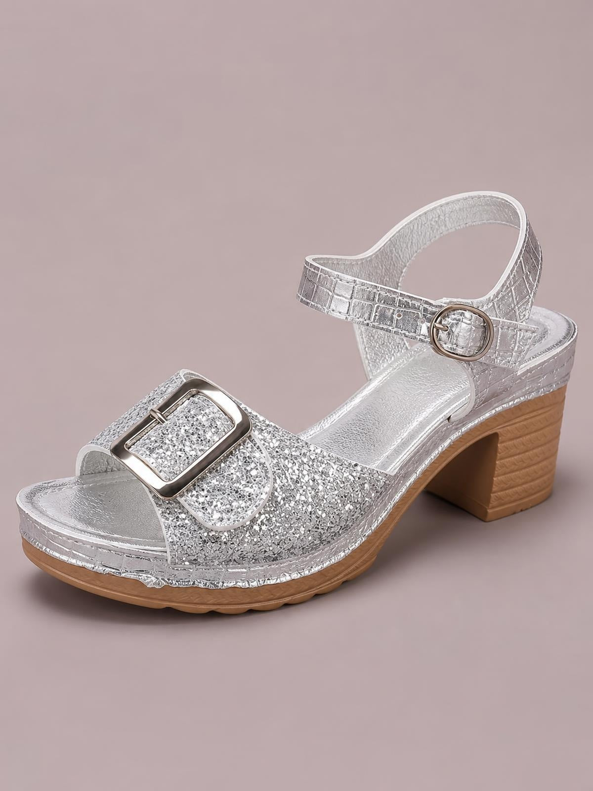 Silver glitter buckle sandals feature an open toe, adjustable ankle strap, textured platform sole, and comfortable mid-height block heel.
