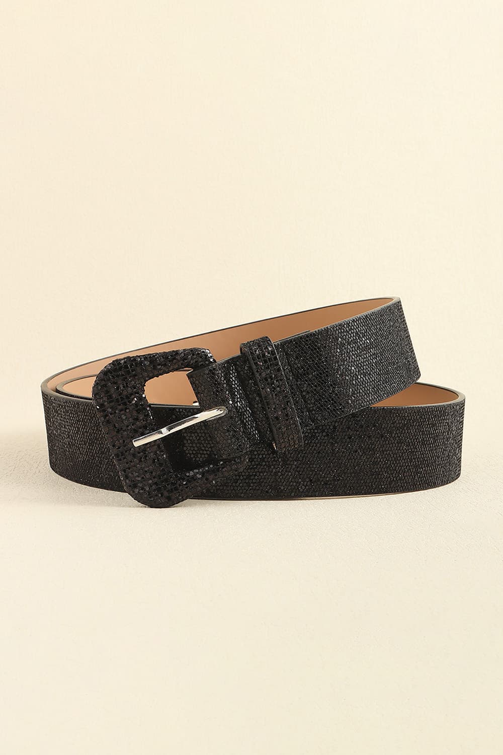 Black glitter PU leather belt displayed coiled, featuring a slim textured strap and structured rectangular buckle with a polished metal prong.