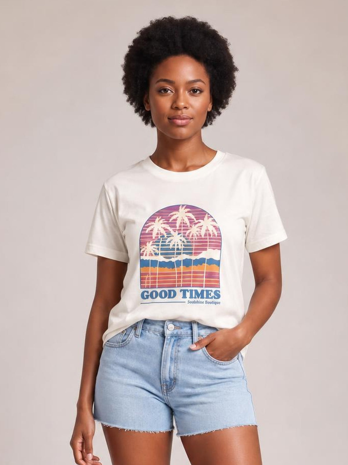 A model poses in a white graphic round neck short sleeve T-shirt with a colorful palm tree print and relaxed straight silhouette.