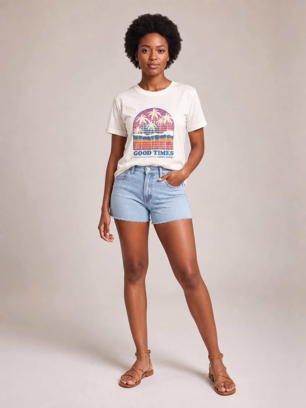Model wearing an opaque white graphic round neck short sleeve T-shirt with a relaxed silhouette, palm tree print, and one hand in her shorts pocket.