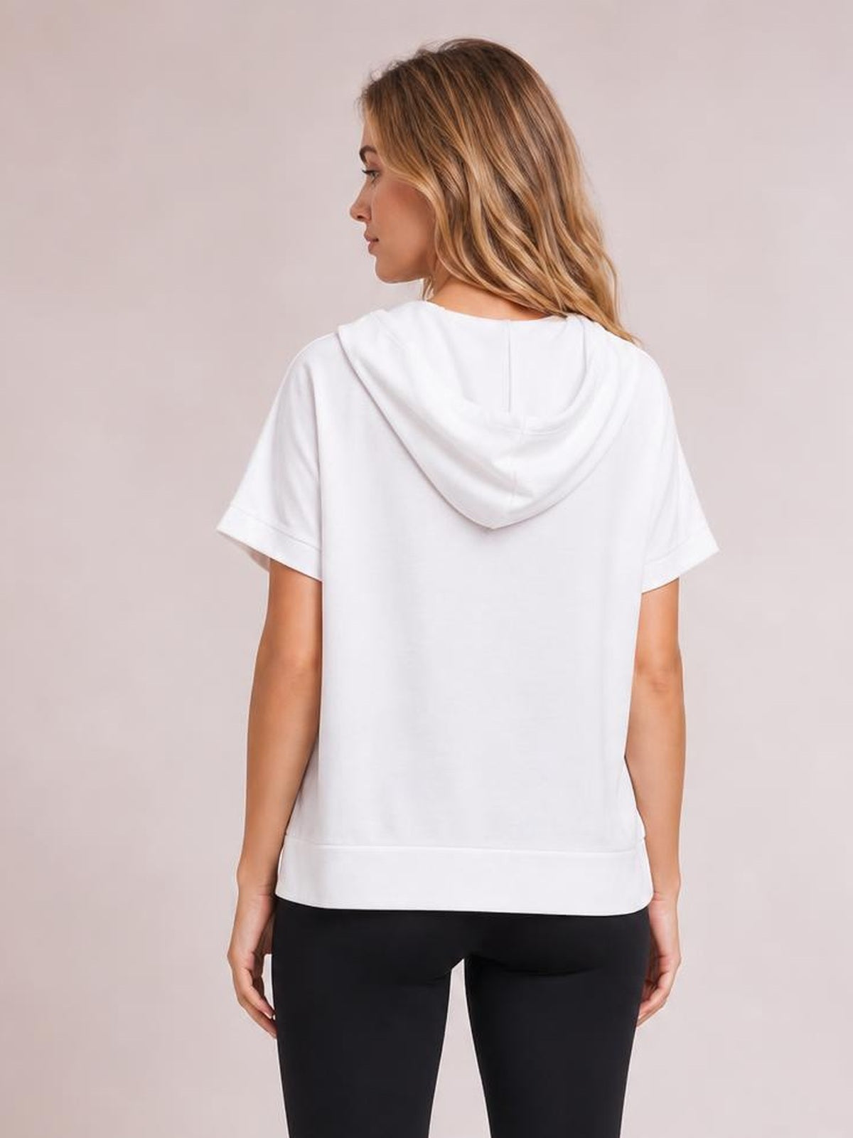 Model shown from behind wearing a white short-sleeve hooded top with a relaxed straight silhouette, draped hood, and finished ribbed hem.