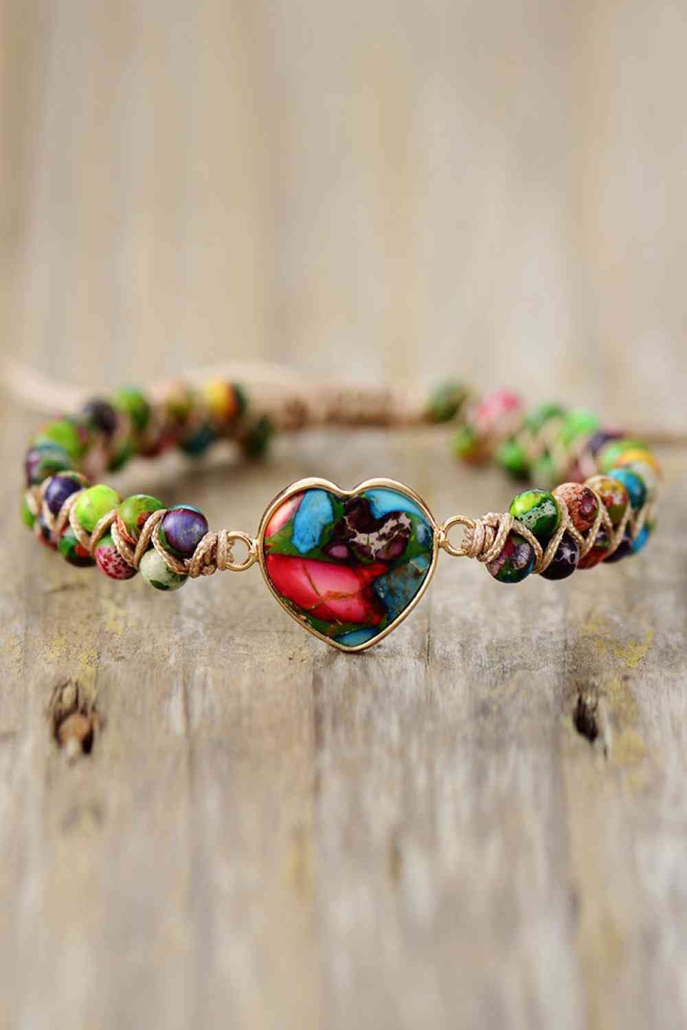 Handmade modern bracelet with a colorful heart-shaped natural stone centerpiece, copper-toned edging, and a woven chain of multicolored stone beads.