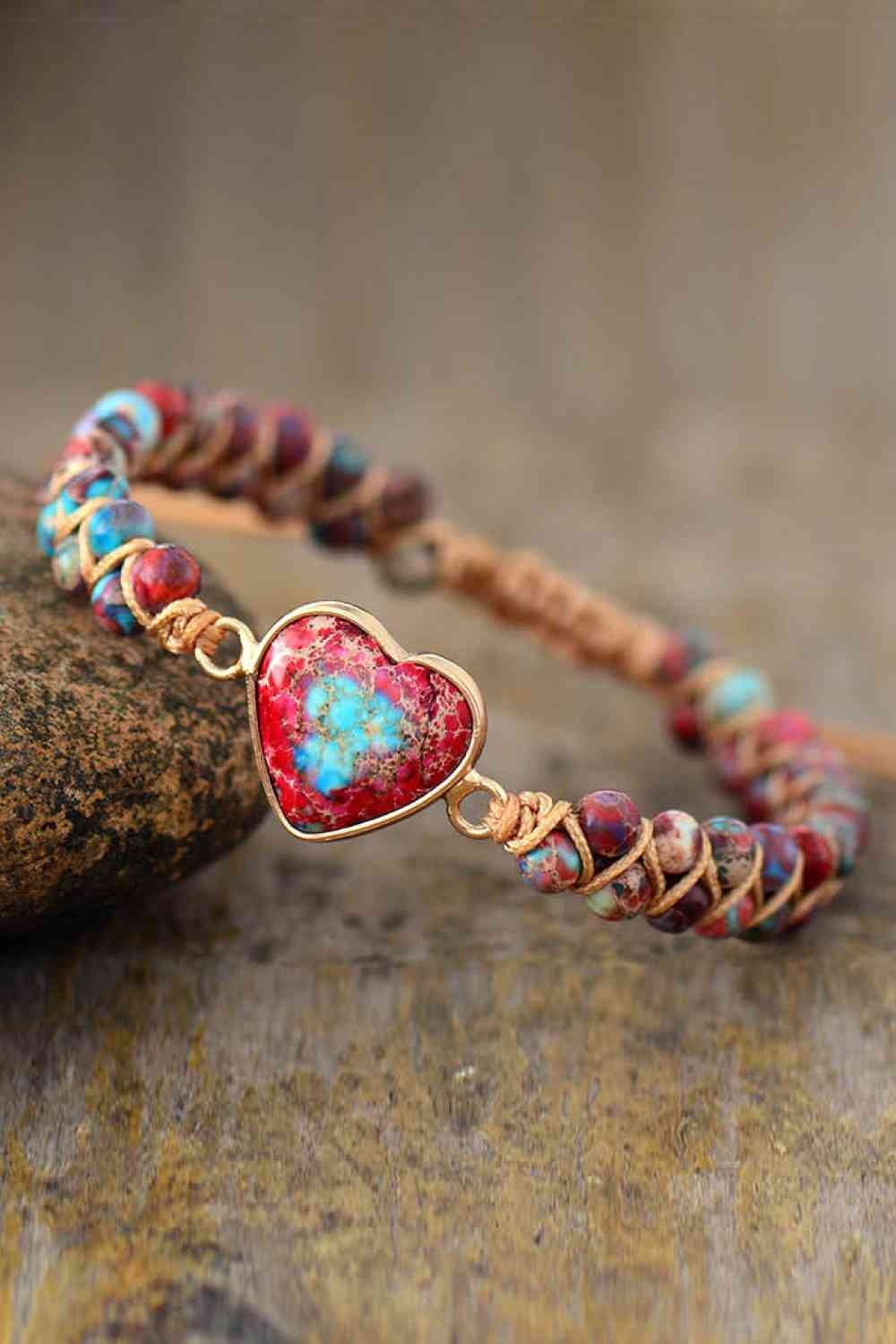 Handmade modern bracelet featuring a copper-framed heart-shaped natural stone centerpiece with vivid red, blue, and multicolored stone beads on a braided cord.