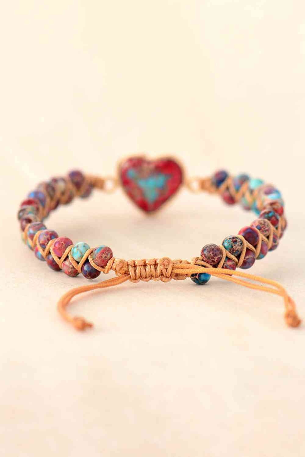 Handmade modern bracelet with a heart-shaped natural stone centerpiece, colorful polished stone beads, copper-toned accents, and an adjustable woven cord closure.