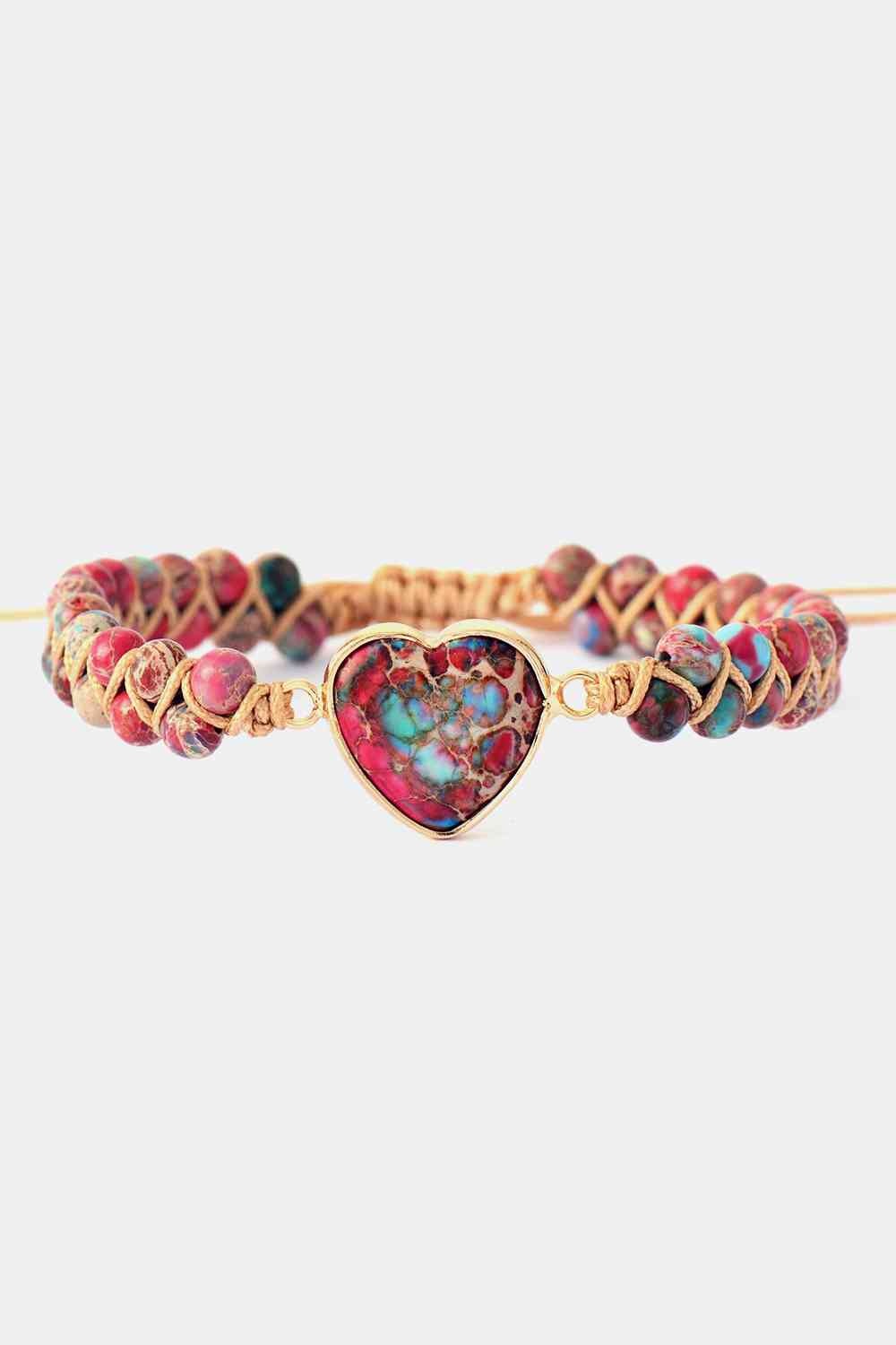 Handmade heart-shape natural stone bracelet with a colorful marbled heart centerpiece, copper-toned setting, and braided cord strung with multicolored stones.