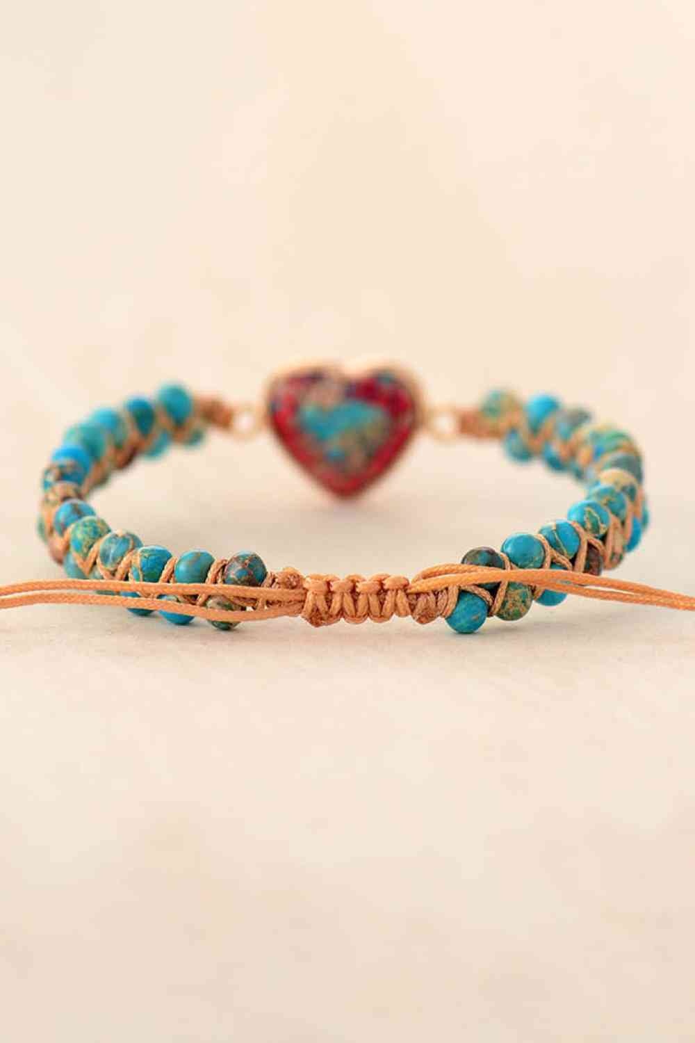 Handmade modern bracelet with turquoise natural stone beads, a heart-shaped stone centerpiece, and a tan adjustable cord with a knotted closure.