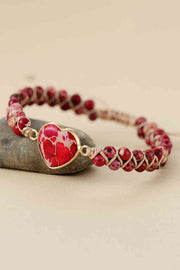 Handmade modern bracelet featuring a red natural stone heart centerpiece, matching marbled beads, and a copper-tone chain with woven cord construction.
