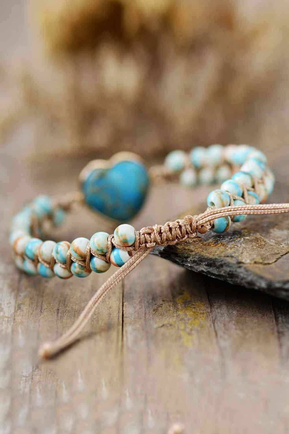 Handmade bracelet with turquoise-and-white natural stone beads, a blue heart-shaped stone accent, copper-toned chain, and adjustable woven cord closure.
